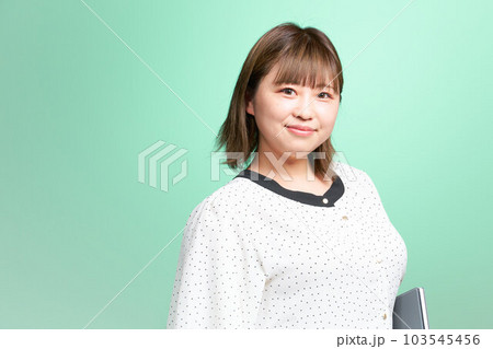 タブレットを小脇に抱える若い女性 ビジネスカジュアル タブレットを小脇に抱える若い女性 ビジネスカジュアル 103545456