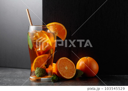Iced tea or a summer refreshing drink with ice, mint, and orange. 103545529