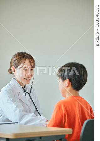 聴診器をお腹に当てて診察する若い女性医師 103546151