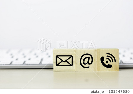 Concept of contact us. wooden cube blocks with contact icons on table computer keyboard background. Concept of contact us. wooden cube blocks with contact icons on table computer keyboard background. 103547680