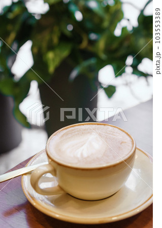 Coffee cup with a heart pattern in a blue cup on a wooden background 103553389