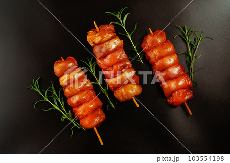 Chicken Skewers meat.Close up of chicken meat.Procurement for designers.Fresh raw marinated skinless chicken leg meat skewers with fresh herbs on a black background.Top view.Copy space. Chicken Skewers meat.Close up of chicken meat.Procurement for designers.Fresh raw marinated skinless chicken leg meat skewers with fresh herbs on a black background.Top view.Copy space. 103554198