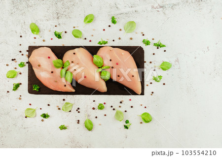 Raw fresh chicken fillet on a gray background with fresh herbs.Copy space.Food for retail.Ogranic food,healthy eating.Food concept.Top view.Chicken breast Fillets.Close up.Raw chicken meat. 103554210