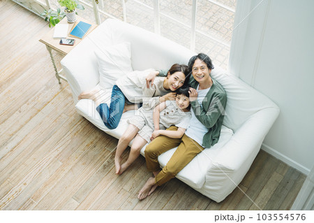 家のリビングのソファーに座る家族のポートレート 家のリビングのソファーに座る家族のポートレート 103554576