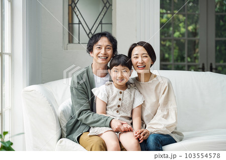 家のリビングのソファーに座る家族のポートレート 家のリビングのソファーに座る家族のポートレート 103554578