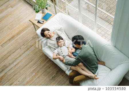 家のリビングのソファーで戯れ合う家族 103554580