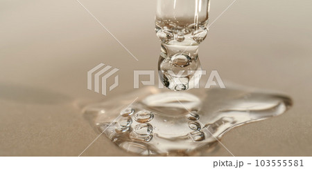 The texture of serum or oil with a pipette on a beige background. The texture of serum or oil with a pipette on a beige background. 103555581