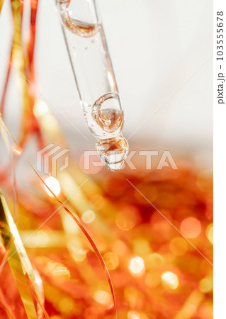 Pipette with gel on the background of tinsel. 103555678