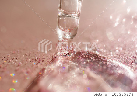 The texture of the serum or oil on an emerald background. 103555873