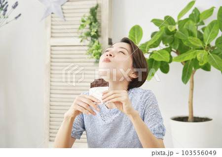 自宅で板チョコを食べる女性 自宅で板チョコを食べる女性 103556049