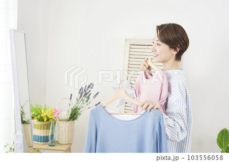 家で洋服を選ぶ女性 家で洋服を選ぶ女性 103556058