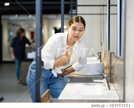 Female positive customer choosing faucet or spigot combination set for water supply Female positive customer choosing faucet or spigot combination set for water supply 103557251