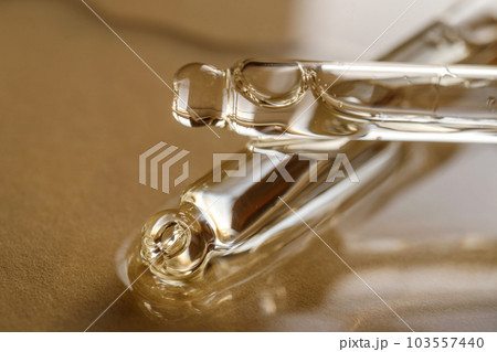 Pipettes with oil or serum on a golden background. Pipettes with oil or serum on a golden background. 103557440
