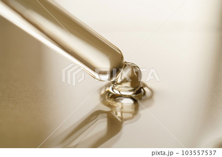 Pipettes with oil or serum on a golden background. 103557537