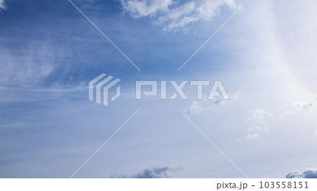 昼の青空に流れる雲と太陽による彩光 103558151