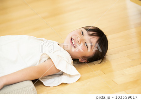 フローリングに寝転ぶ女の子 103559017