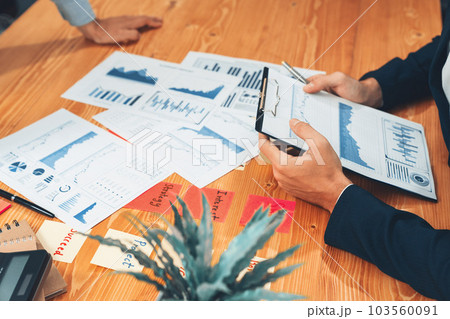 Analyst team in office analyzing financial data analysis papers. Entity 103560091
