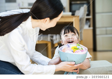お母さんに花束を渡す女の子 103560121