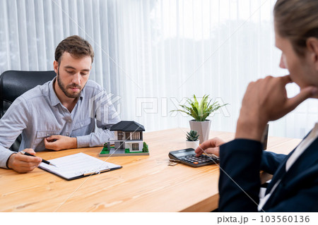 Client and real estate agent review loan contract and discussing term. Entity 103560136