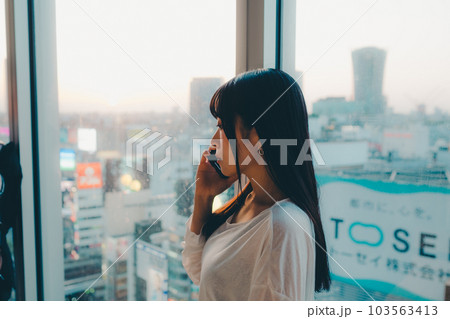 都会の夕焼けに佇む若い女性 都会の夕焼けに佇む若い女性 103563413