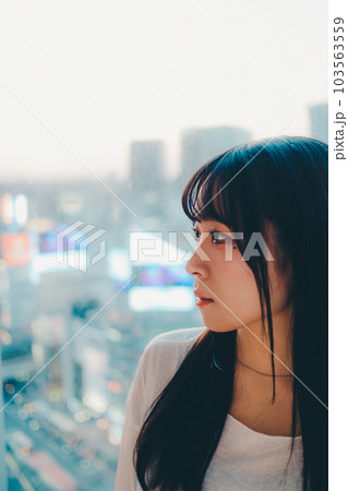都会の夕焼けに佇む若い女性 103563559