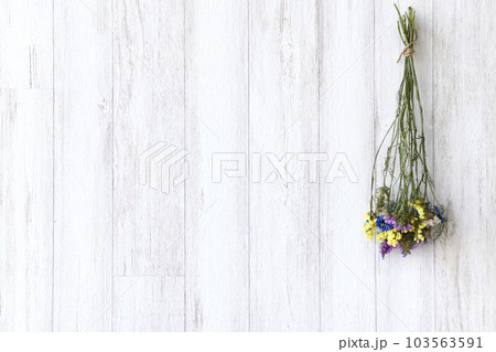 白木の壁に吊るされたドライフラワー 103563591