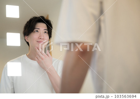 髭やスキンケアを鏡で確認する男性 103563694