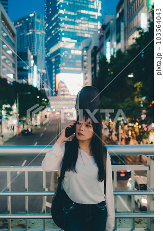 ギターとスマホを持って佇む若い女性 ギターとスマホを持って佇む若い女性 103564043
