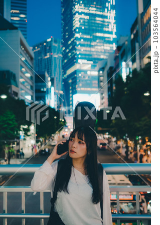 ギターとスマホを持って佇む若い女性 ギターとスマホを持って佇む若い女性 103564044