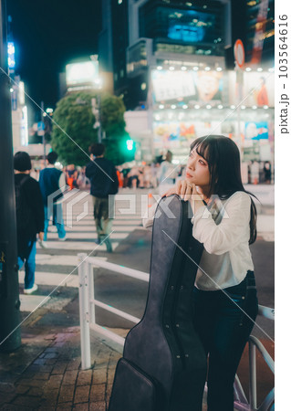 ギターを持って佇むクールな若い女性 103564616