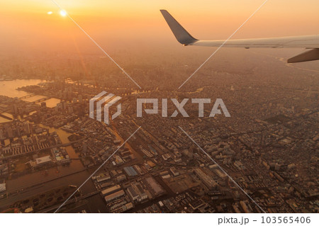 夕焼けの飛行機の窓の外（東京湾岸） 103565406