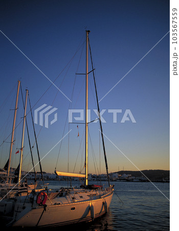 エーゲ海に沈む夕日を受けたクルーザーヨット 103567559