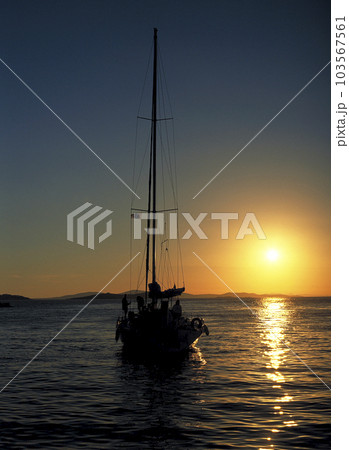 エーゲ海に沈む夕日を受けたクルーザーヨットのシルエット エーゲ海に沈む夕日を受けたクルーザーヨットのシルエット 103567561