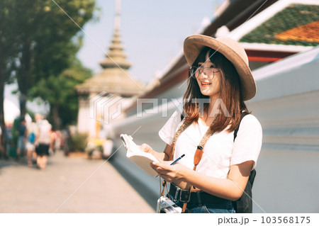Young adult asian travel woman at landmark temple outdoor on day. Bangkok, Thailand. Young adult asian travel woman at landmark temple outdoor on day. Bangkok, Thailand. 103568175