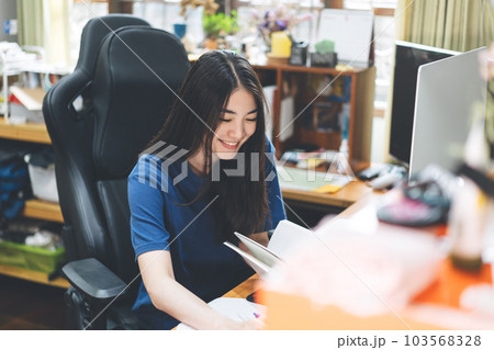 Young adult artist freelancer wear headset asian woman in workplace space with window light on day. 103568328