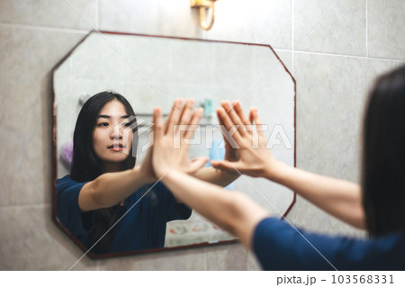 Young adult smile asian woman practice self talk conversation in the morning in bathroom at home. Young adult smile asian woman practice self talk conversation in the morning in bathroom at home. 103568331