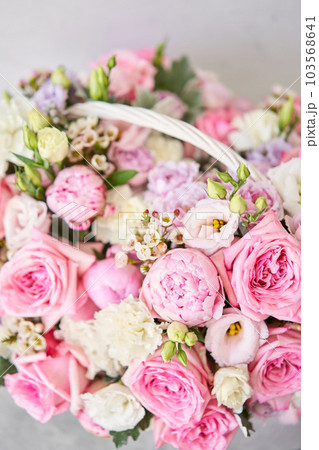 Flower arrangement in Wicker basket. Beautiful bouquet of mixed flowers on a marble table. Floral shop concept . Handsome fresh bouquet. Flowers delivery Flower arrangement in Wicker basket. Beautiful bouquet of mixed flowers on a marble table. Floral shop concept . Handsome fresh bouquet. Flowers delivery 103568641