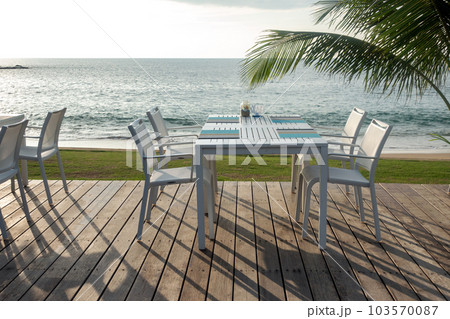 table set near the sea at sunset time. 103570087