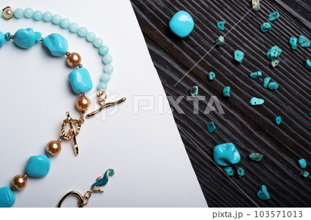 author collection jewelry with azure gemstones, pearls and chain demonstrated at white and black background.  fashion and jewelry concept. flat lay 103571013
