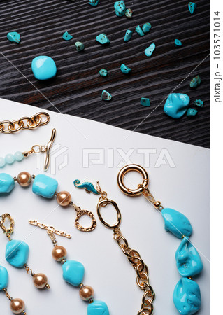 author collection jewelry with azure gemstones, pearls and chain demonstrated at white and black background. fashion and jewelry concept. flat lay author collection jewelry with azure gemstones, pearls and chain demonstrated at white and black background. fashion and jewelry concept. flat lay 103571014