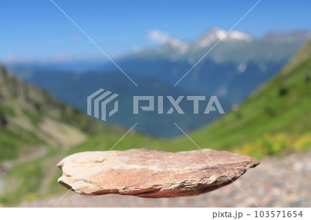 A podium made of flying stone with a natural backdrop to the mountains. Front showcase with a stand for the presentation of goods. With a beautiful view of the mountains and the blue sky. 103571654