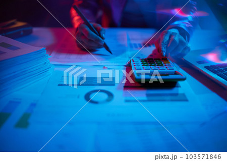 Closeup on modern woman with calculator exploring charts 103571846