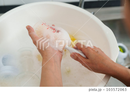 mother hand washing baby plastic milk bottle 103572063