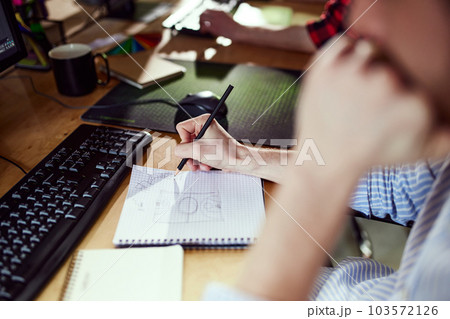 Close-up image of male hands, graphic designer working, doing sketches in notebook. Planning work 103572126
