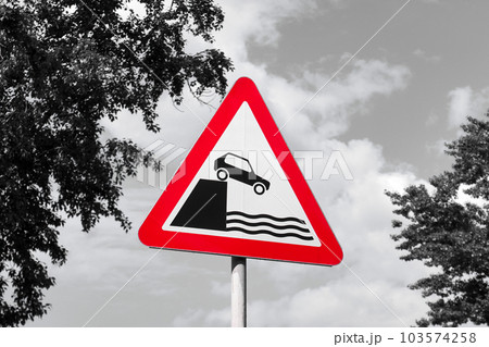 Unprotected quayside or riverbank, warning sign. Only red color filter used on image Unprotected quayside or riverbank, warning sign. Only red color filter used on image 103574258