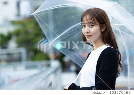 雨の日、帰宅する女性 103576369