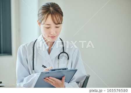 患者に問診をする若い女性医師 103576580