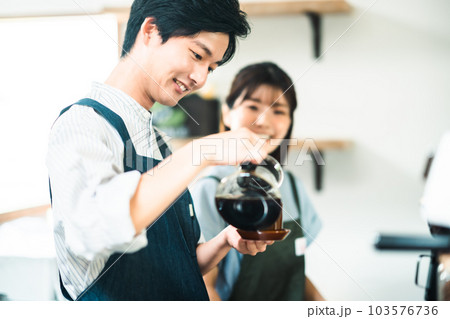 カフェでアルバイトをする若い男女 103576736