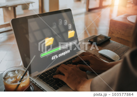 Transfer files data system relocation concept, Person hand using laptop computer waiting for transfer file process with loading bar icon on virtual screen. Transfer files data system relocation concept, Person hand using laptop computer waiting for transfer file process with loading bar icon on virtual screen. 103577864