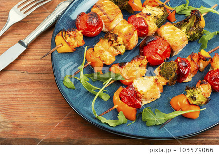 Fish salmon skewers on old wooden board. 103579066